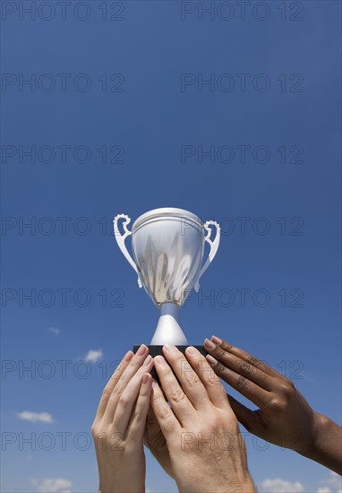Hands holding trophy in the air.
