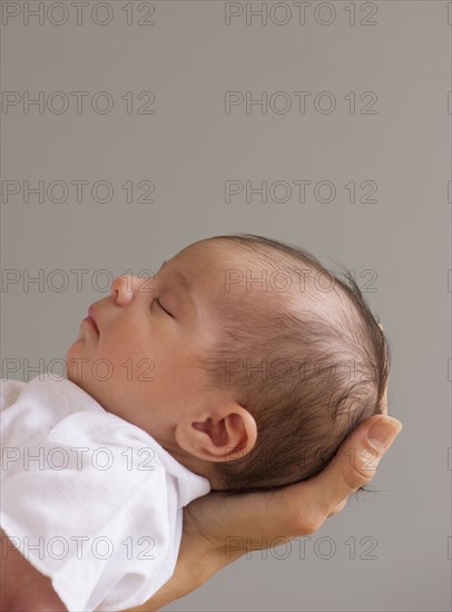 Baby sleeping in mother's hands.