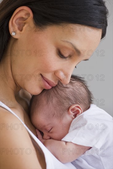 Mother holding sleeping baby.