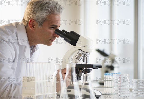 Researcher looking through microscope.