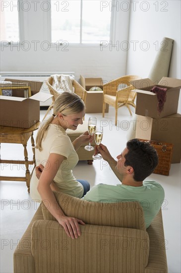 Happy couple toasting with champagne in their new home.