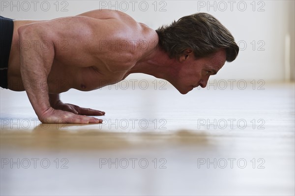 Muscular man doing push-ups. Photo : Daniel Grill