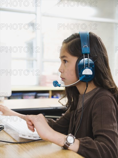 Elementary student wearing headphones in classroom.