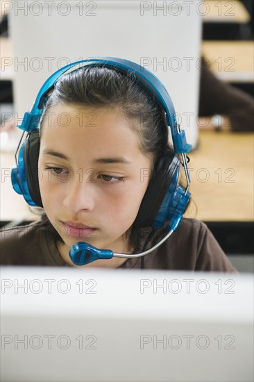 Elementary student wearing headphones in classroom.