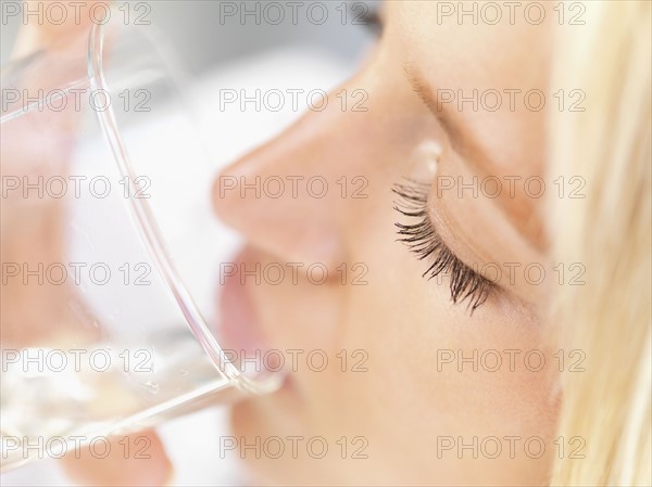 Woman drinking a glass of water. Photo : momentimages