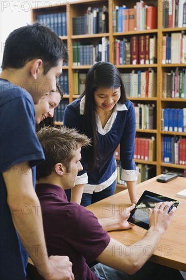 College students looking at electronic book.