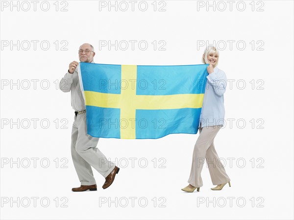 Two people carrying the flag the Swedish flag. Photo : momentimages