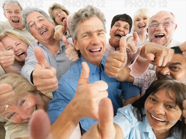 A group of people giving the thumbs up sign. Photo : momentimages