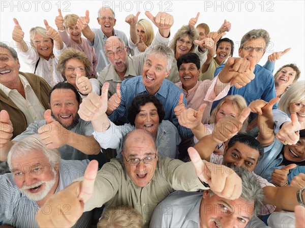 A group of people giving the thumbs up sign. Photo : momentimages