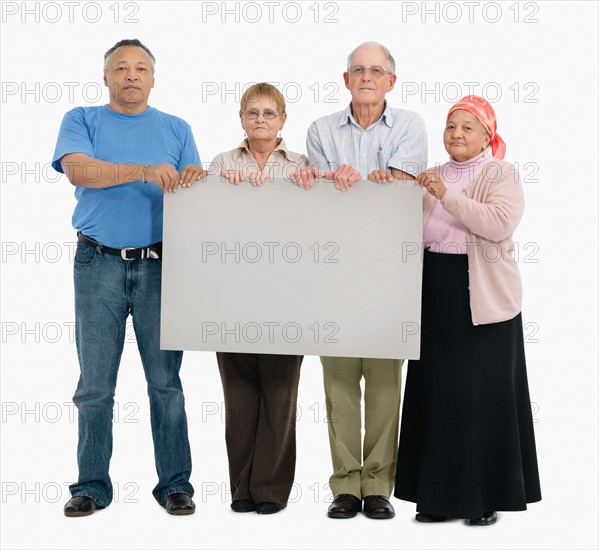 Four people holding a blank poster. Photo : momentimages