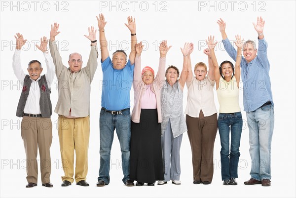 A group of people standing in a row raising their arms. Photo : momentimages