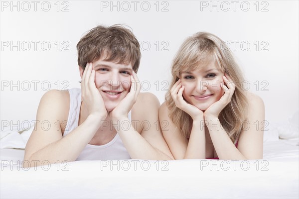 Couple lying side by side in bed. Photo : Take A Pix Media