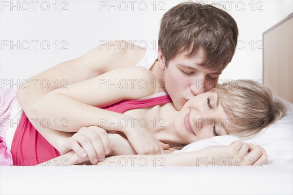 Man kissing woman in bed. Photo : Take A Pix Media