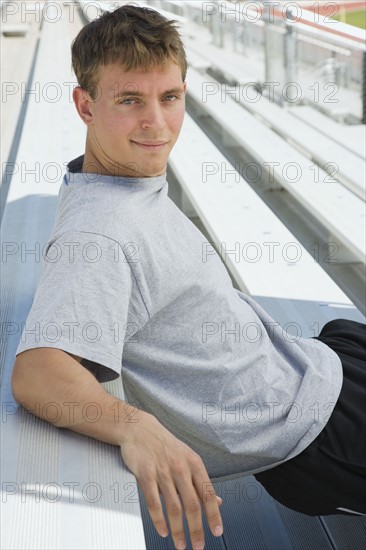 Confident athlete sitting on bleachers. Photo : Stewart Cohen
