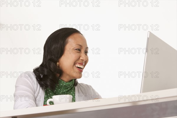 Happy woman looking at laptop. Photo : K.Hatt