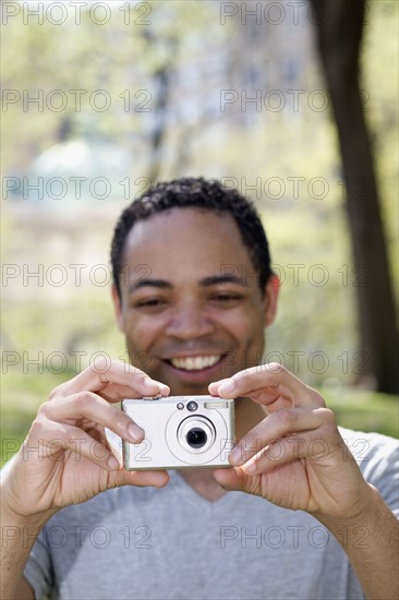 Man taking photograph in Central Park. Photo : David Engelhardt