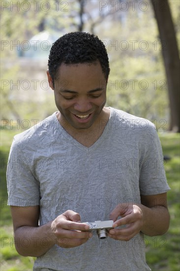 Man looking at photograph on digital camera. Photo : David Engelhardt