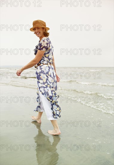 Woman walking on the beach. Photo : Shawn O'Connor