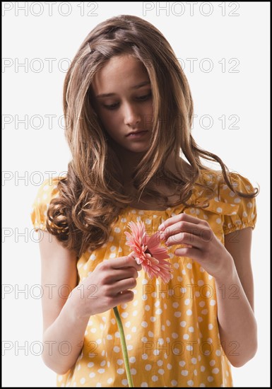 Teenage girl picking petals off of a flower. Photo : Mike Kemp