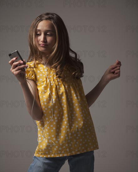 Teenage girl listening to music on I pod. Photo : Mike Kemp