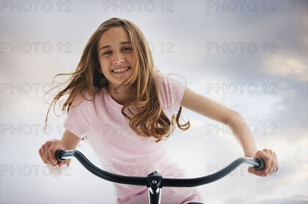 Pretty teenage girl riding a bike. Photo : Mike Kemp