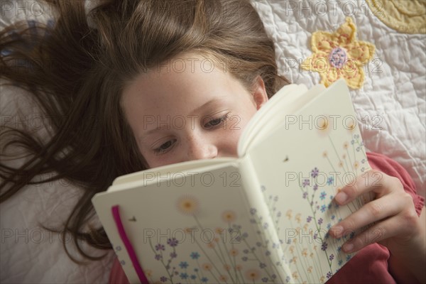 Young girl reading her diary. Photo : Mike Kemp