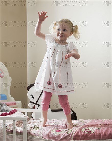 Young girl dancing on her bed. Photo : Mike Kemp