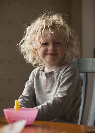 Young girl sitting at breakfast table. Photo : Mike Kemp