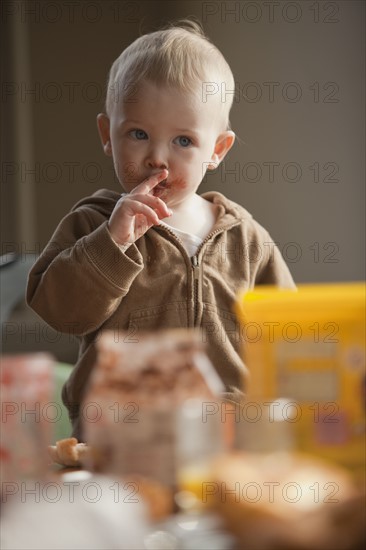 Baby licking food off fingers. Photo : Mike Kemp