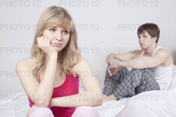 Couple sitting on bed after arguing. Photo : Take A Pix Media