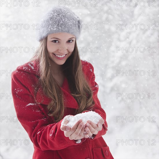 Woman holding snow in her hands. Photo : Mike Kemp