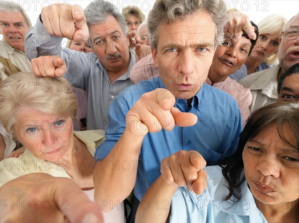 A group of people pointing their fingers in accusation. Photo : momentimages