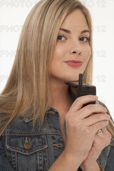 Pretty blond woman holding cell phone. Photo : K.Hatt