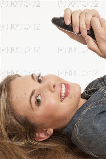 Pretty blond woman holding phone. Photo : K.Hatt