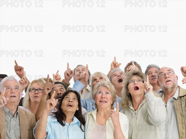 A group of shocked people pointing up. Photo : momentimages