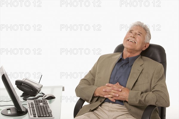 Businessman relaxing at his desk. Photo : K.Hatt