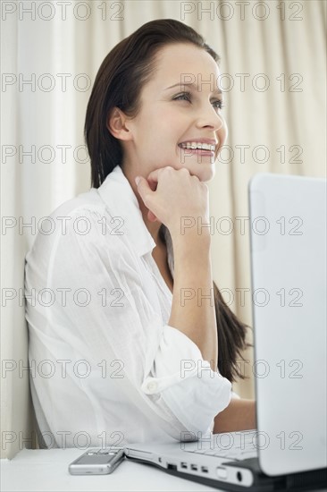 Pretty woman sitting in front of laptop. Photo : momentimages