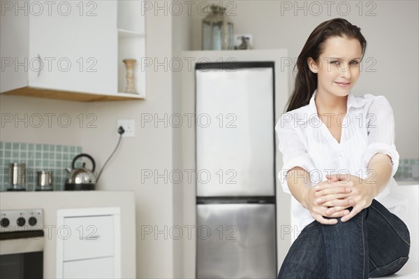 Woman relaxing in kitchen. Photo : momentimages