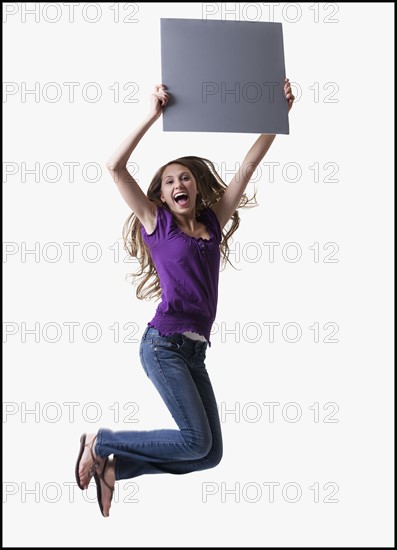 Teenage girl jumping for joy. Photo : Mike Kemp