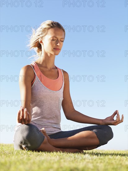 Woman meditating outside. Photo : momentimages