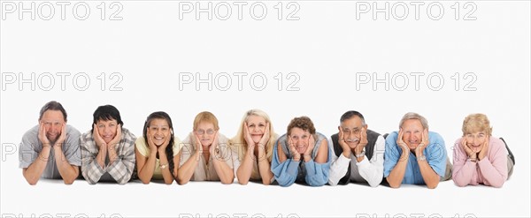 A group of people lying on the floor in a row. Photo : momentimages