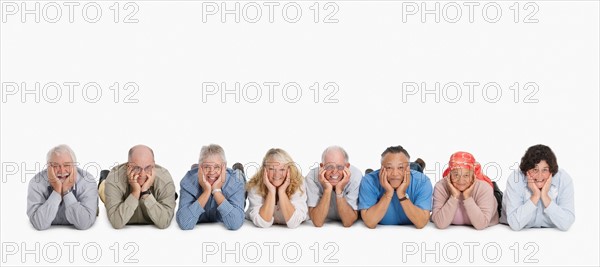 A group of people lying on the floor in a row. Photo : momentimages