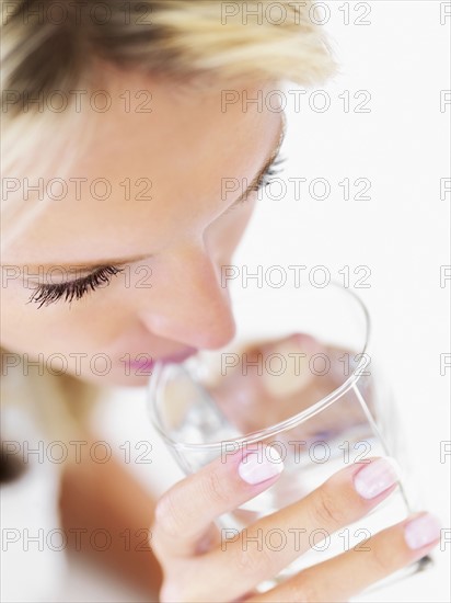 Woman drinking a glass of water. Photo : momentimages