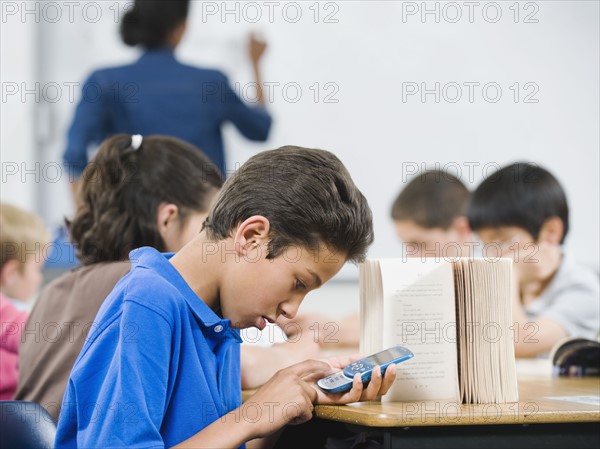 Student texting in classroom.