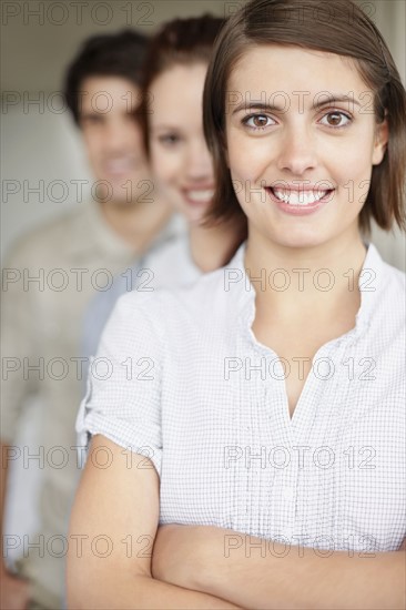 Three people standing in a row. Photo : momentimages