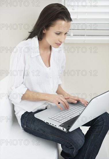 Woman typing on laptop. Photo : momentimages