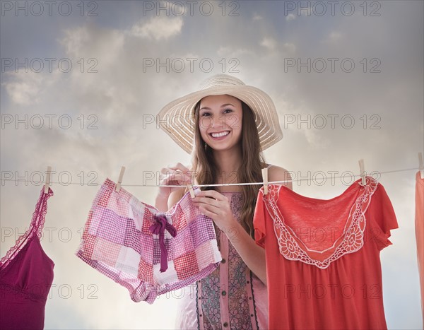 Woman hanging laundry on clothesline. Photo : Mike Kemp