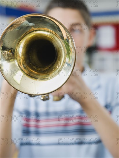 Elementary school student playing trumpet.