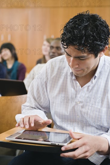 College students taking notes in lecture hall.