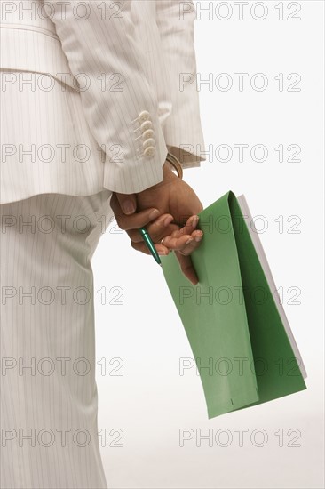 Businesswoman holding paperwork behind her back. Photo : K.Hatt